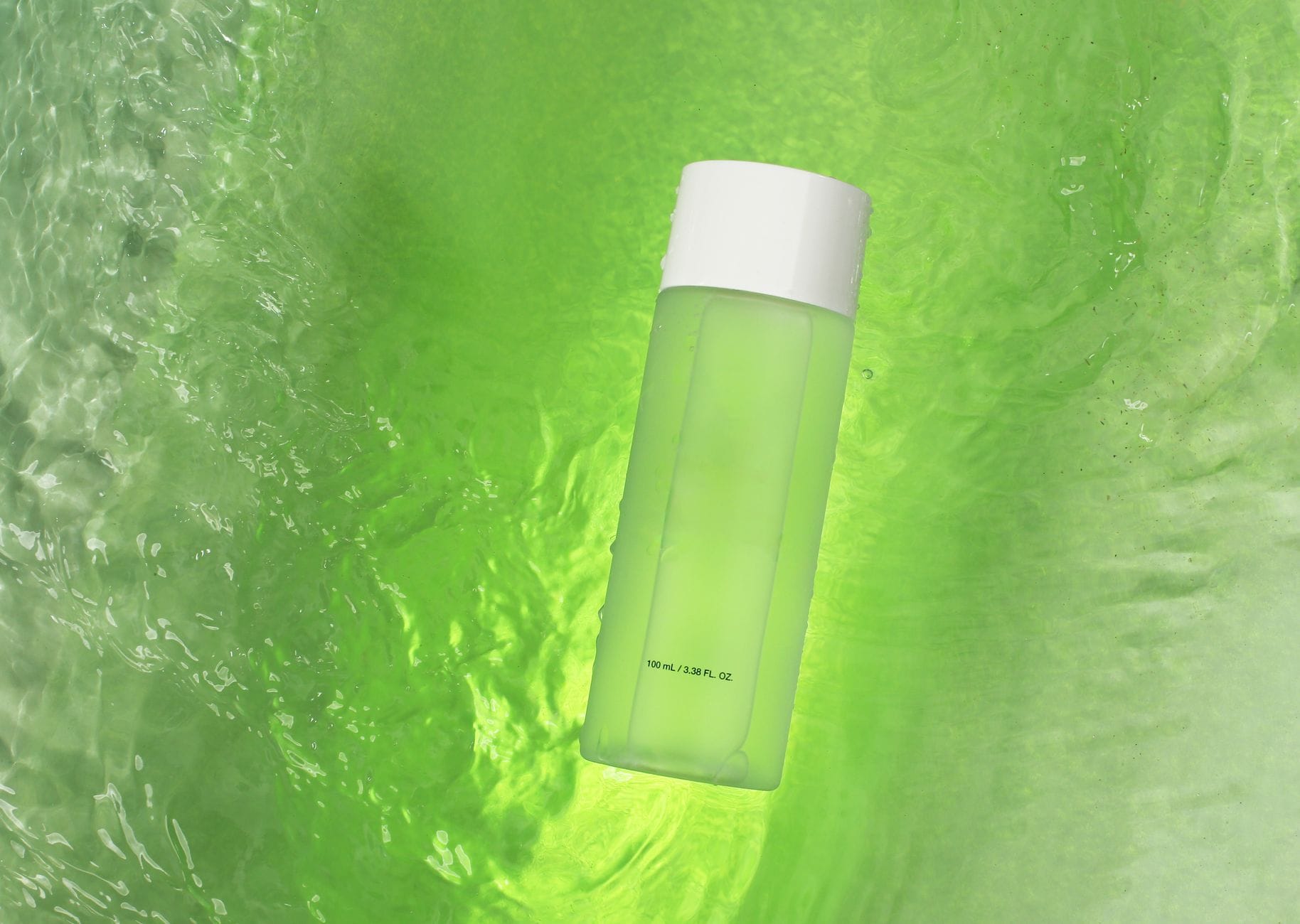 Naturalne bufery pH w hydrolatach i tonikach: jak wpływają na mikrobiom skóry Zielona butelka unosząca się na wirującym zielonym tle płynu